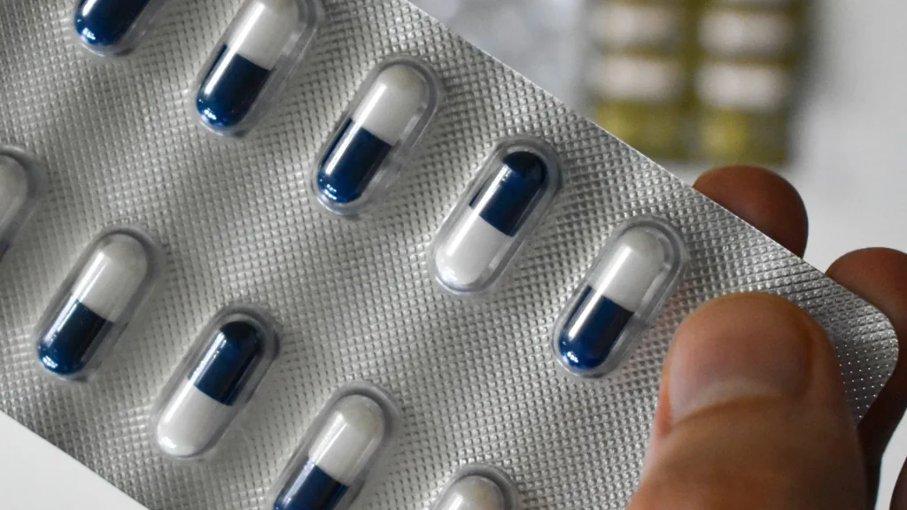 Blíster de cápsulas de antibiótico sostenido en la mano durante un tratamiento